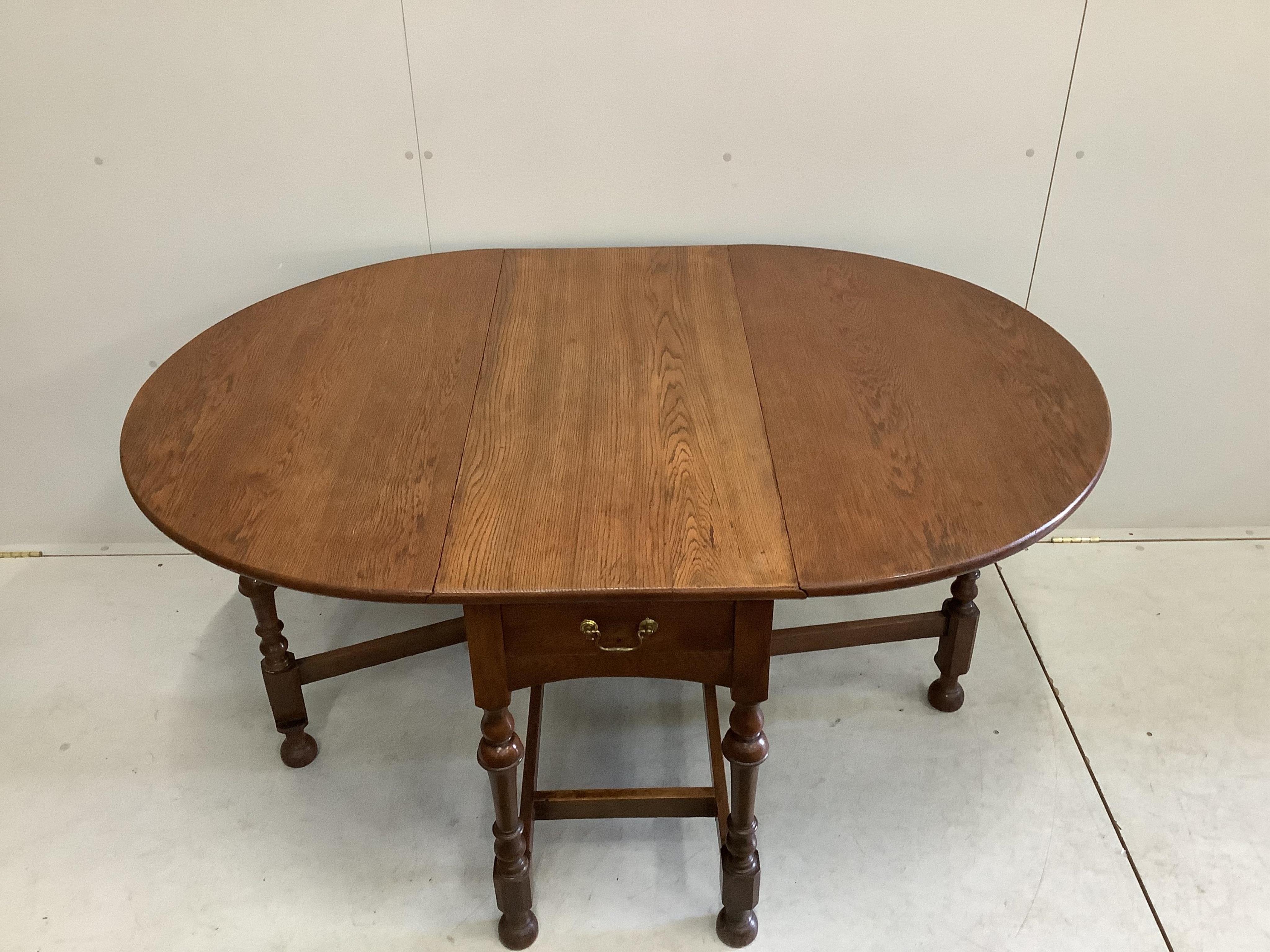 An early 20th century oak gateleg dining table, width 107cm, depth 47cm, height 74cm. Condition - fair to good